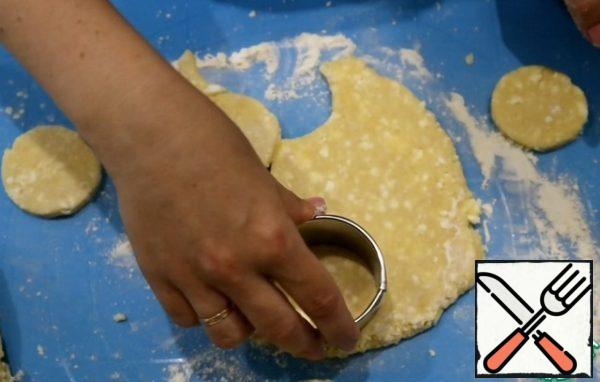 The dough is divided into 4 parts. From each form a cake thickness of 7-8 mm. Using the form cut out the circles.