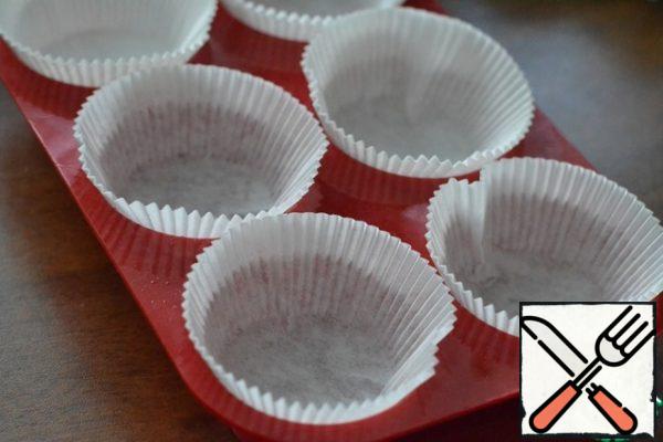 Prepare forms for muffins, grease them with sunflower oil.
I have paper forms, but it is better to use silicone.