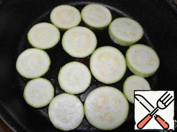In a frying pan, heat the oil, put the zucchini.