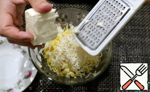 On a small grater grate boiled eggs (boil them for 10 minutes) and melted cheese.
