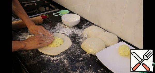Roll out each piece of dough with a diameter of about 22-25 cm. Put the filling in the center of the ball and assemble it according to the type of khinkali. I level it slightly with my hands, and then roll it out with a rolling pin to the diameter I need. I was starting from the size of my frying pan. You can roll out some more. The dough will turn out thinner, I think it will only taste better. But carefully, so that the dough does not break and the filling does not leak out.
