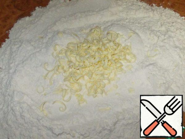 Sift the flour onto the table and rub the frozen butter three times. Periodically stirring with flour.
