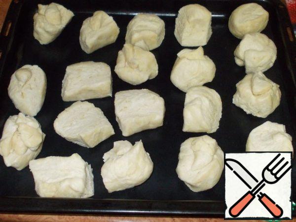 The dough is extracted from the freezer and divided into portions weighing 70 grams. If there are no scales, then focus on the size of a large chicken egg. The tray with the dough is sent to the refrigerator.