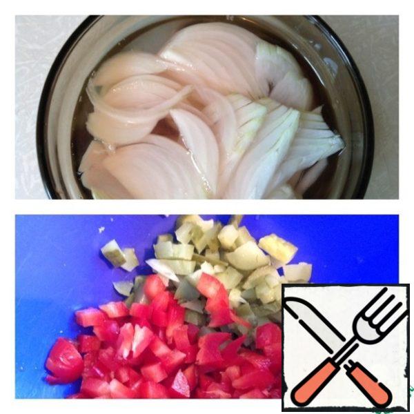 Pour water into a bowl, add sugar and vinegar. Cut the pickled onion into half rings. Leave it on for 15 minutes.
Cucumber and pepper cut into small cubes.
