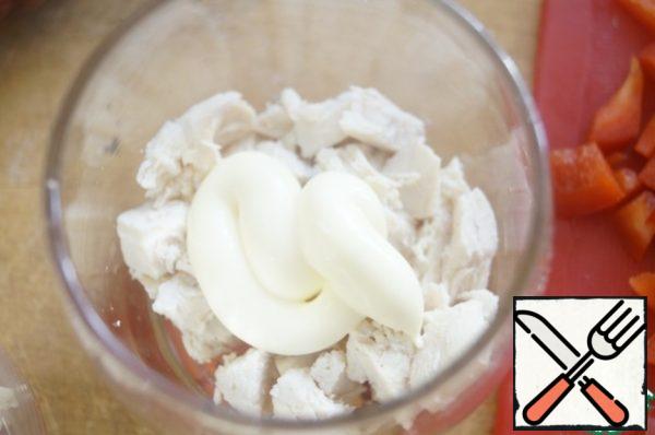 First, at the bottom of the glass spread chopped chicken, a little salt and grease with mayonnaise.