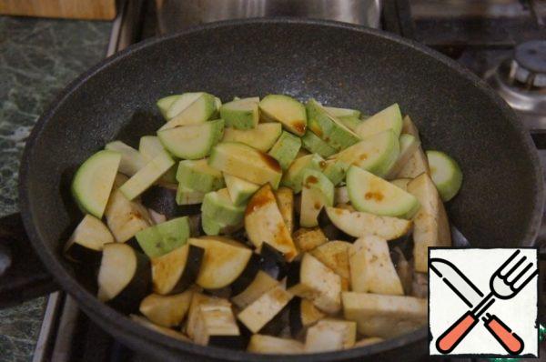 Then pour the eggplant and zucchini, stir, pour the soy sauce and cook for another 2 minutes.