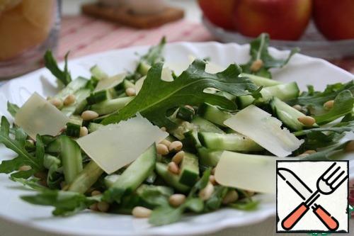 Grate cheese on a medium grater or finely chop.
Mix salad and cucumber.
In a Cup mix the oil, balsamic, salt, pepper and honey.
Pour dressing salad, then sprinkle with nuts, cheese.