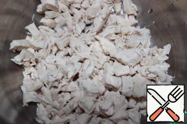 Boil chicken fillet, cool and cut into small pieces.