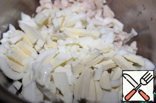 Boil the eggs, peel and slice. Add to the chicken.
