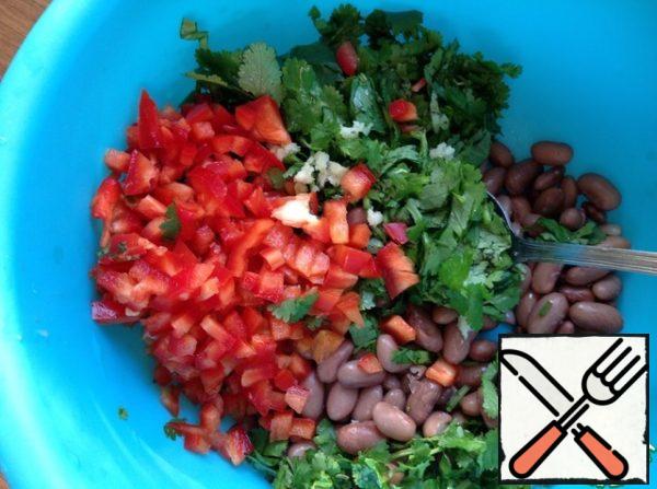 Add garlic, passed through a press, finely chopped coriander to the boiled beans.
Bulgarian pepper cut into small cubes.
