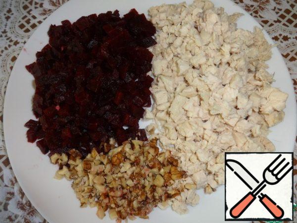 Cut into cubes beet, chicken breast, too, cut into cube. Nuts chop. Squeeze the garlic.