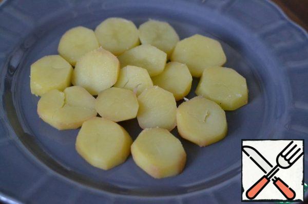 Boil potatoes in their skins.
Peel and cut into circles.
Spread on a plate for serving.