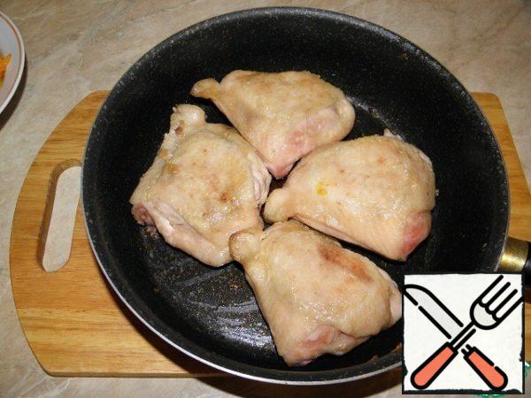 Chicken cut into portions, fry in a pan with heated vegetable oil on both sides, shift into a saucepan .