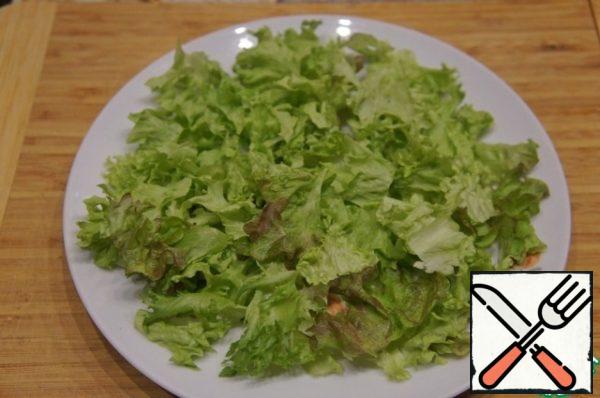 Lettuce pick hands, most of the put on a flat dish, closing the bottom. The rest is poured into a deep bowl.