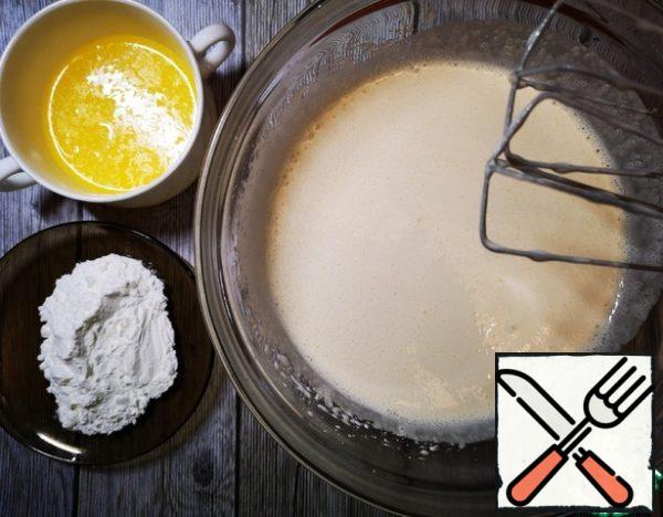 Proteins are separated from the yolks, add sugar and whisk until fluffy. Then, continuing to whisk, enter the yolks, melted butter and starch.