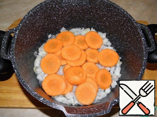 Cut the carrots into large slices and add to the onion.
