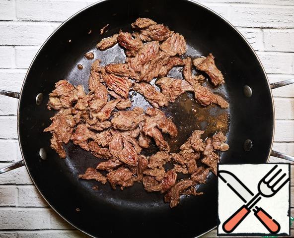 On a well-heated dry frying pan without adding oil for 1 minute, fry the meat for an appetizing crust. Using tongs or sticks to constantly stir and flip.