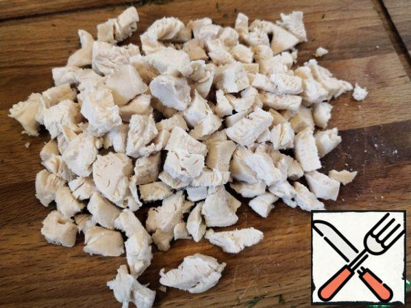 Rinse the chicken fillet, put it in boiling salted water and cook until tender for 15-20 minutes. Remove from the broth and cool. Cut into cubes.
