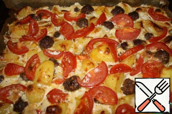 At the end of 40 minutes, take out a baking sheet, spread sliced tomatoes and evenly pour the fill.
Bake for another 20 minutes.
During this time, the crispy potatoes are soaked in the sauce, and the tomatoes are slightly baked.