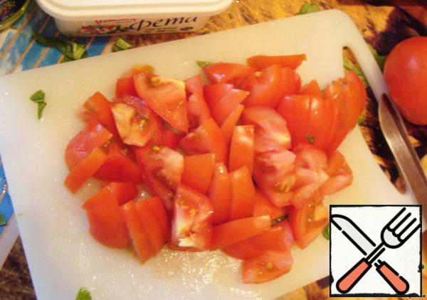 Cut the tomatoes. I like to cut the tomato into 4 parts in a salad, and then each of the four parts into smaller ones. So it spreads less.