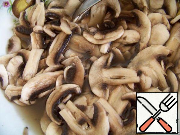 Drain the liquid from the jar with olives (do not pour!!!) in a separate bowl. Spread the mushrooms in it and leave for 10 – 15 minutes.