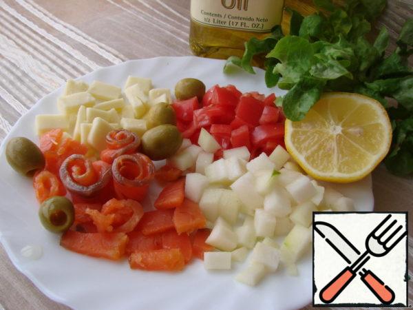Tear the lettuce leaves with your hands, chop the fish, tomato and pear, sprinkle with lemon juice.
