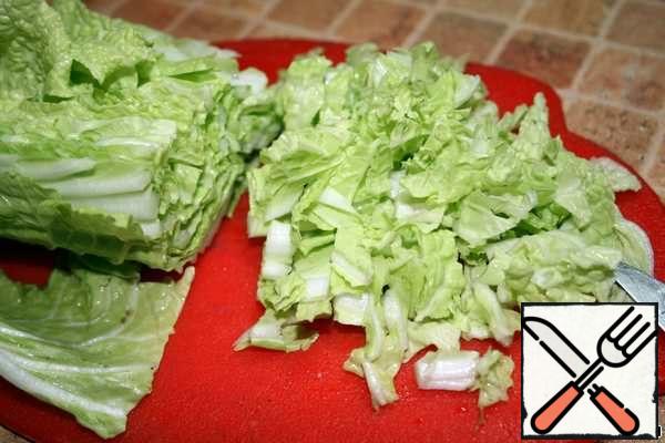 Wash the Peking cabbage, cut the head in half and chop one half finely. Put it in a salad bowl.
