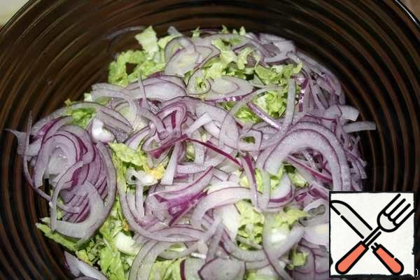 Peel the red onion and cut into thin half-rings. Add to cabbage.