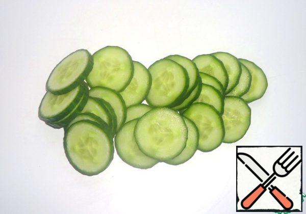 Wash the cucumber and cut it into thin slices.
