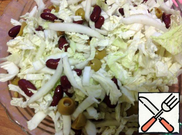 Cabbage shinkuem and add to the olives and beans, mix.