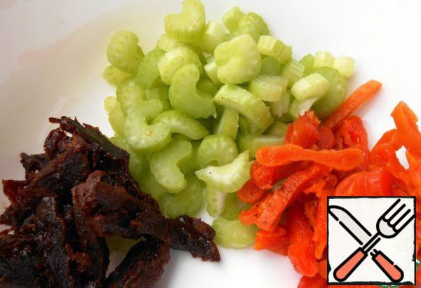 Cut the celery. Pour the dried apricots and prunes with boiling water for 10 minutes, put them on paper napkins to remove excess moisture, then cut into strips.
