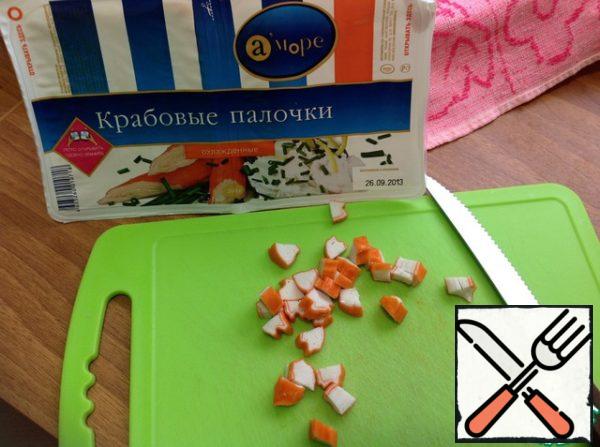 Cut the crab sticks into cubes, add to the salad, mix.