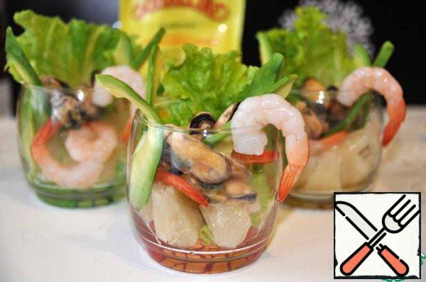 Randomly put pomelo, avocado, smoked mussels and shrimp in a glass.

