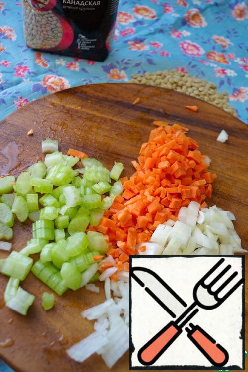 Peel the onions and carrots. Cut into cubes.
Peel the garlic and crush with the flat side of the knife.
Cut the celery stalk into cubes.