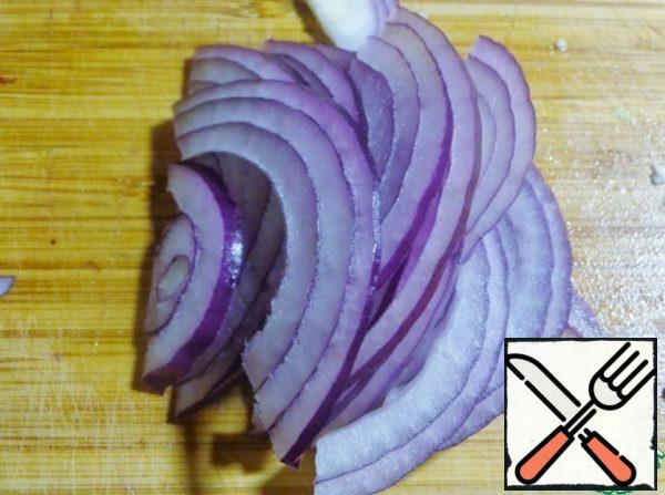 Peel the onion and cut into thin half-rings.