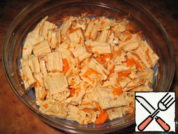 Put the dry asparagus in a deep container and fill with hot water. Leave for 2 hours.
Put the soaked asparagus in a colander.
Peel the carrots and grate them on a coarse grater. Crush the garlic with a special press.
Cut the fuju into 1.5-2 cm pieces, mix with carrots and garlic.
