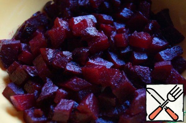 while the beetroot is cooling, peel it and cut into cubes. Put a layer in a flat salad bowl. Season with salt and pepper.
