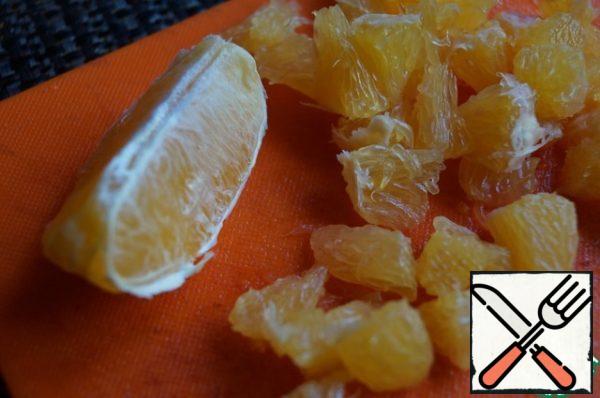 Peel the orange, divide into slices and peel them. Slices cut into small pieces.