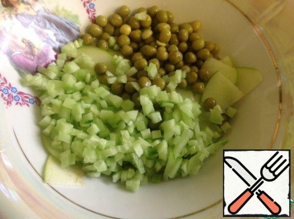 Add green peas, sliced cucumber, previously peeled and seeds to the apple.
Finely chop the green onions and mix everything together.
