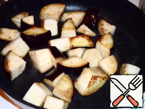 Wash eggplant with cold water. In the pan pour a small amount of vegetable oil and put the pieces of eggplant. 