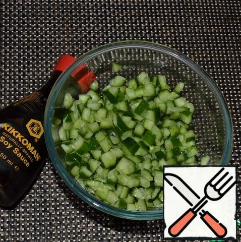 The passage of time, the cucumbers have to get it from the marinade and squeeze. Add garlic and soy sauce, stir.
Sprinkle with sesame seeds.