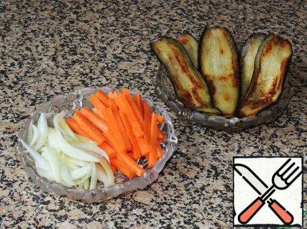 Cut eggplant lengthwise into thin plates. Fry them in vegetable oil on both sides. Carrots cut into cubes, onions , feathers, sauté together for 5-10 minutes.