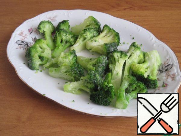 Let's defrost the broccoli and break it into inflorescences.
