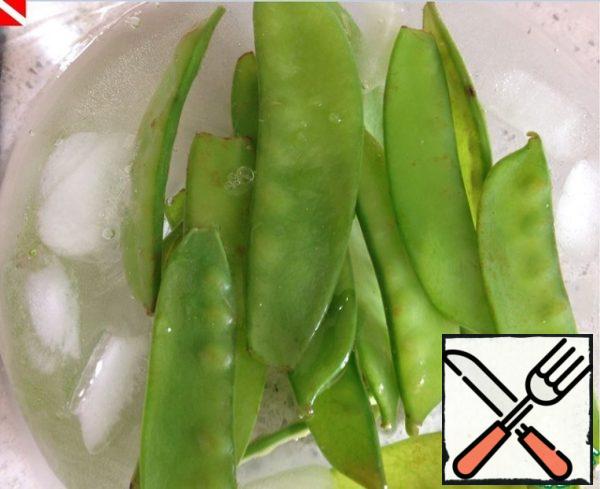 Lower the hot peas into a pre-prepared container with cold water and ice - so that it does not lose its rich bright color.
