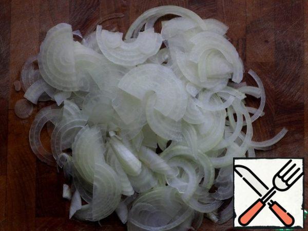 Cut the onion into thin half rings.
