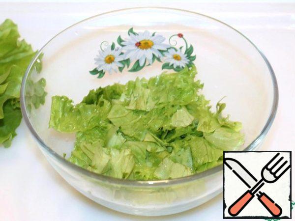 Tear the lettuce leaves with your hands and put them in a bowl.
