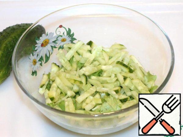 Cut cucumbers into strips, send them to a salad bowl.
