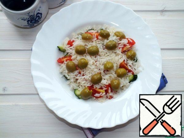 Cut the olives into two halves, add to the crumbly rice.
