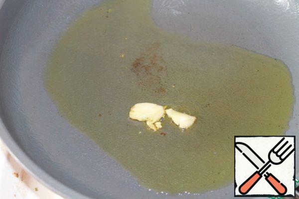 In a frying pan with a thick bottom, heat the olive oil well and throw a clove of garlic into it, after crushing it with a knife.
