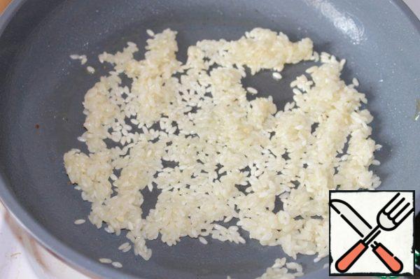 Toss the garlic, pepper the rice and bake it over low heat until transparent.
